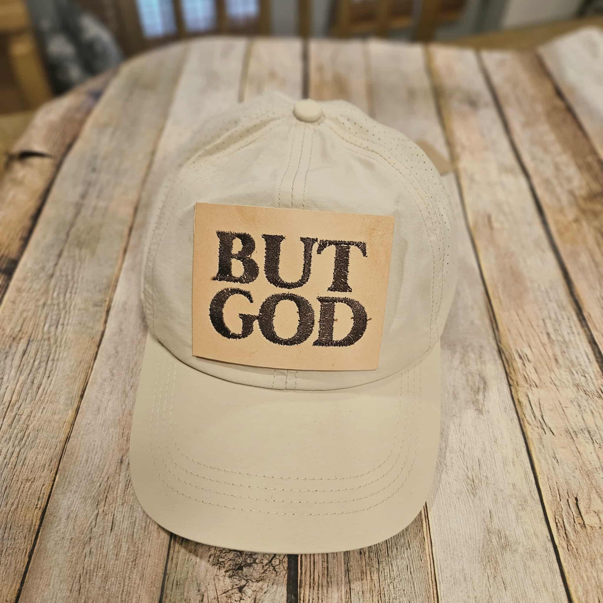 off white crisscross ponytail cap with "but God"  embroidered leather patch