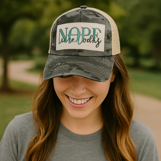 Woman wearing a cap with 'Nape Nobody' text in an outdoor setting