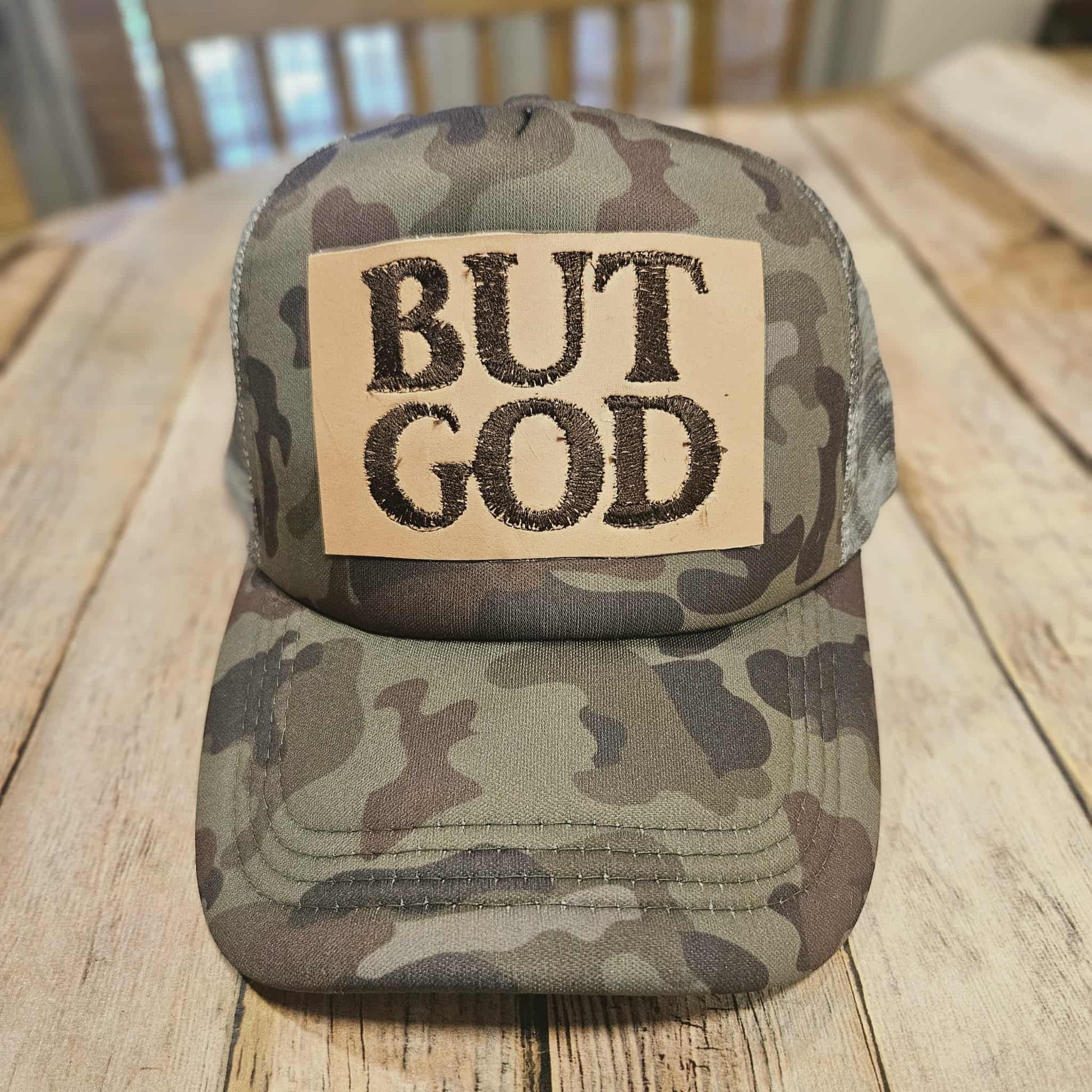 camo trucker cap with "But God" leather embroidered patch