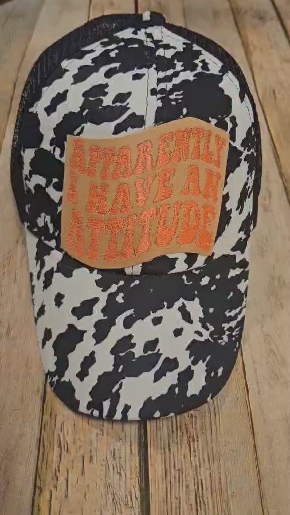 black and white cow print crisscross cap, crisscross ponytail cap, apparently, I have an attitude leather embroidered patch cap, coral embroidered leather patch cap